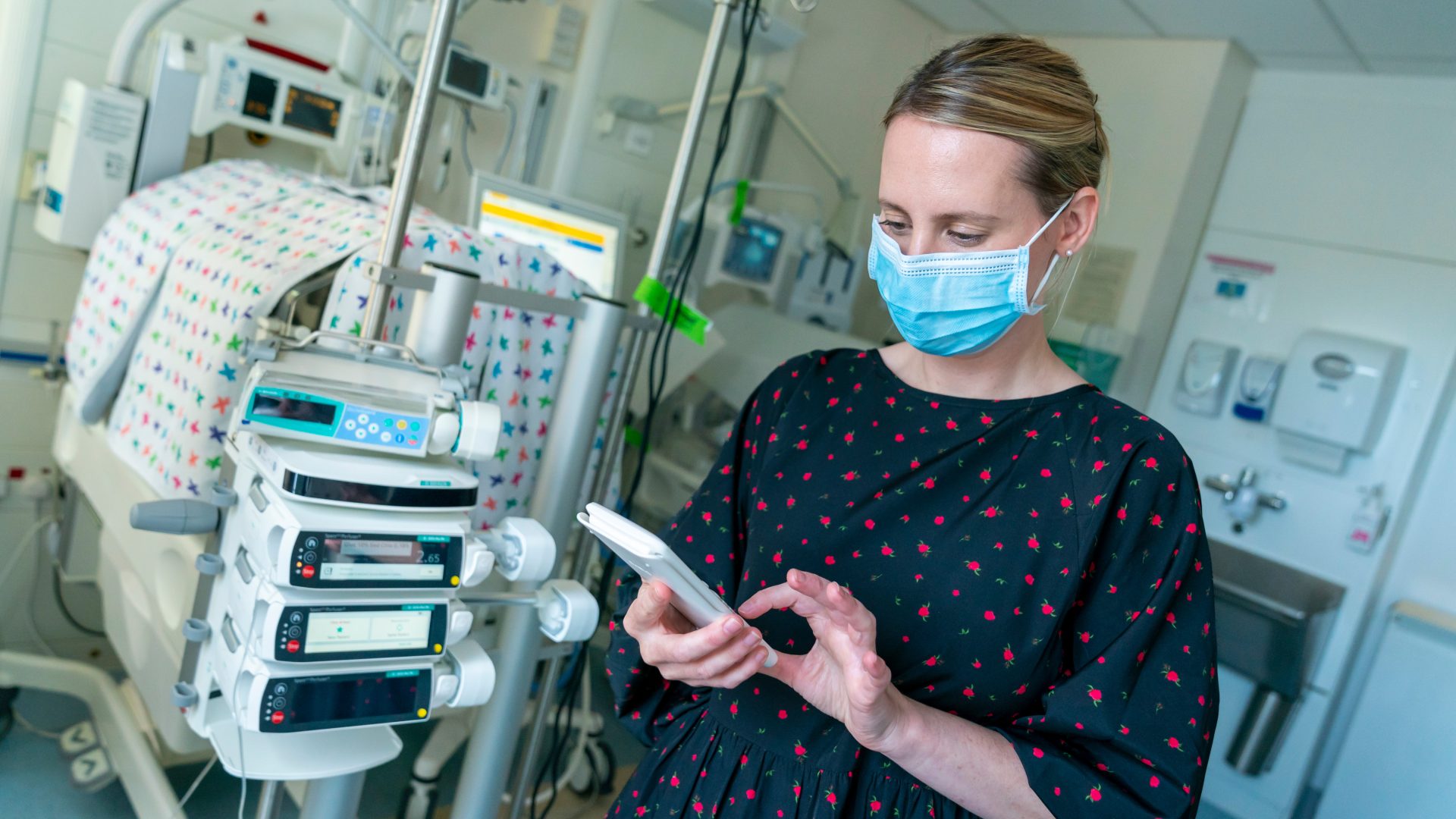 Hospital pharmacist in neonatal unit checking baby's vitals
